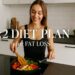 A woman in a kitchen cooks colorful vegetables and chicken in a pan, smiling, with text overlay "5:2 Diet Plan for Fat Loss." The setting feels fresh and healthy.